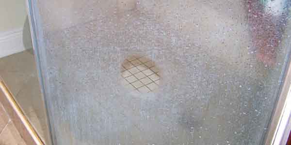 Shower door hard water with a buffed clean spot in the center.